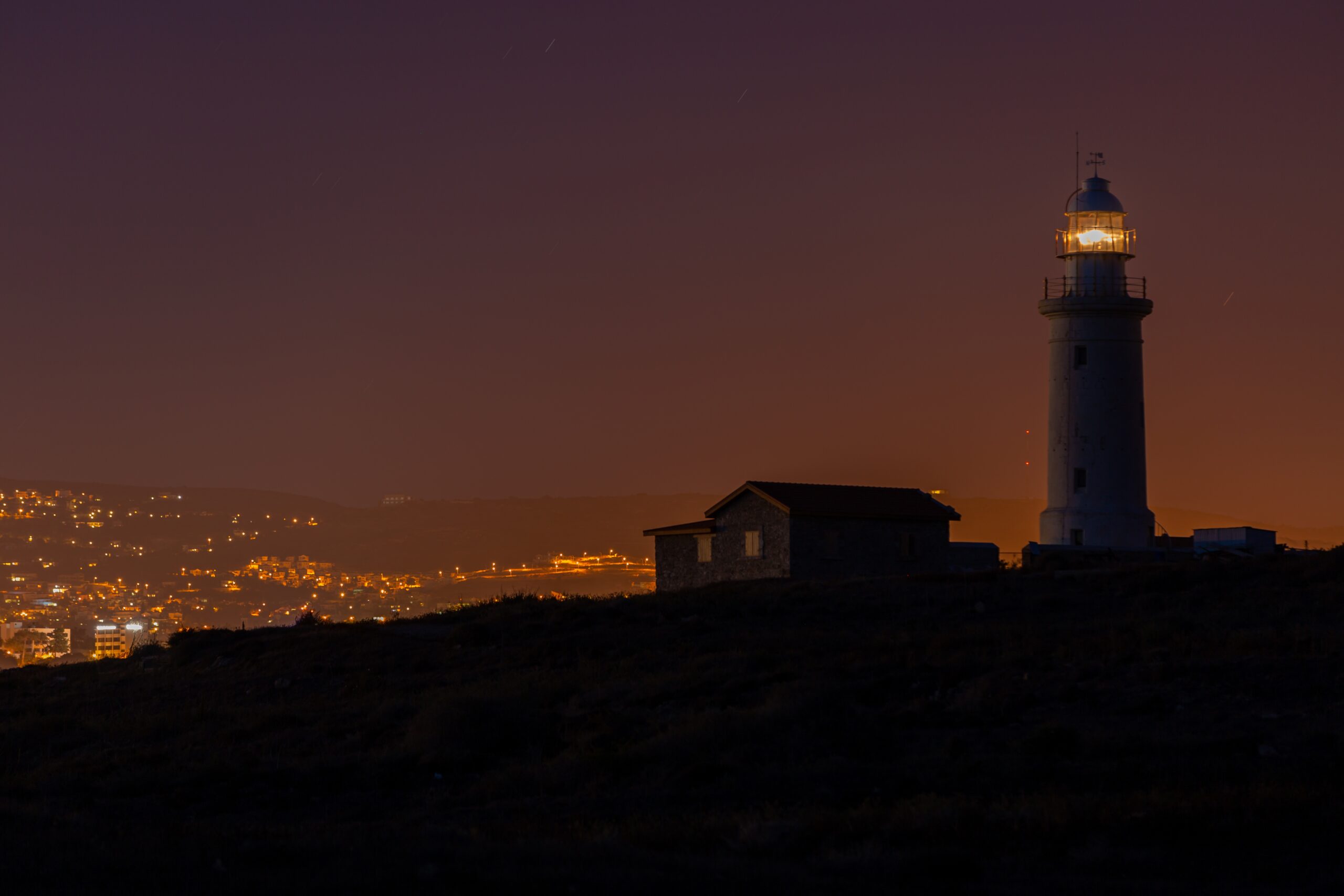Faro de Mazatlan de noche con ciudad de fondo