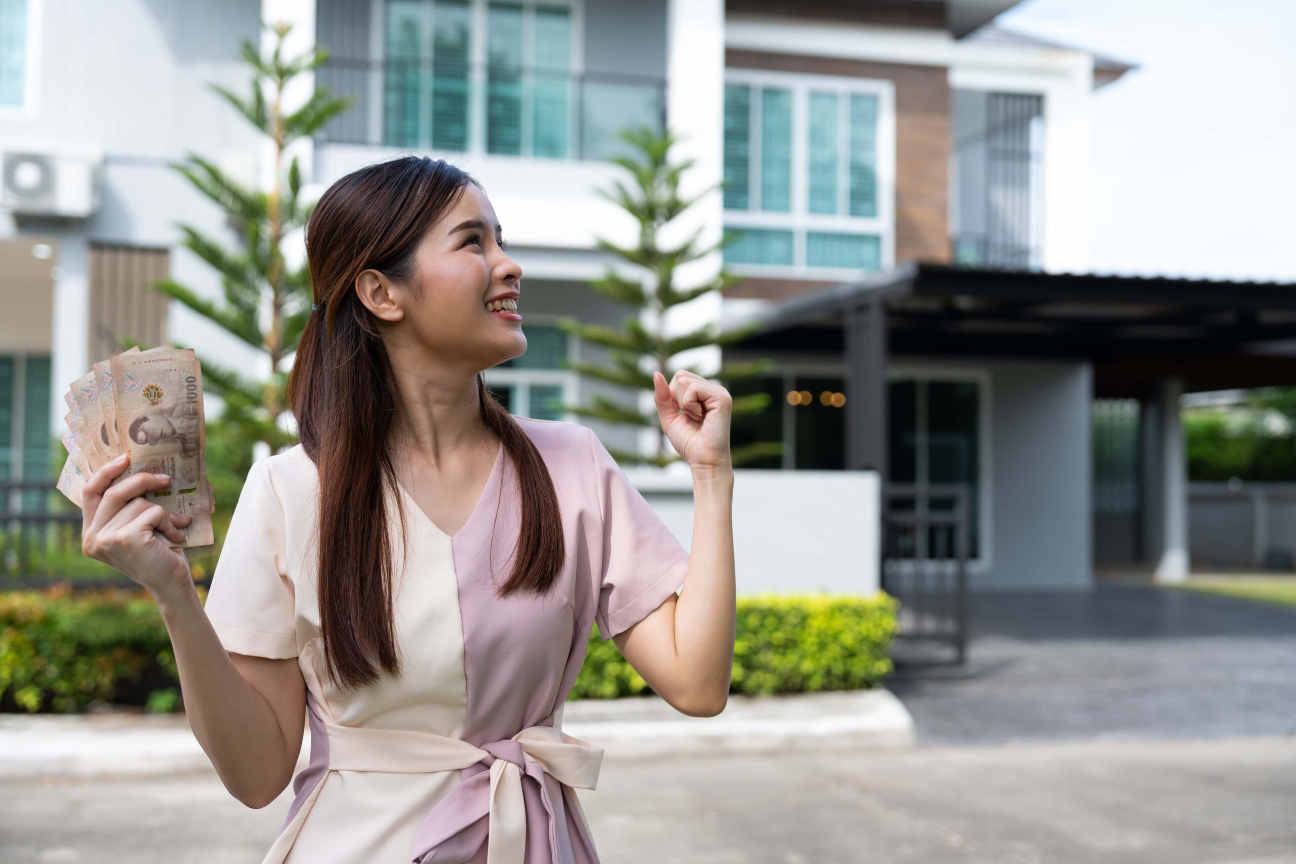 Mujer joven alegre ya cuenta con el dinero para el anticipo y apartado de la compra de casa