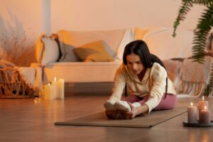 Mujer realizando estiramientos de yoga en la sala de su casa