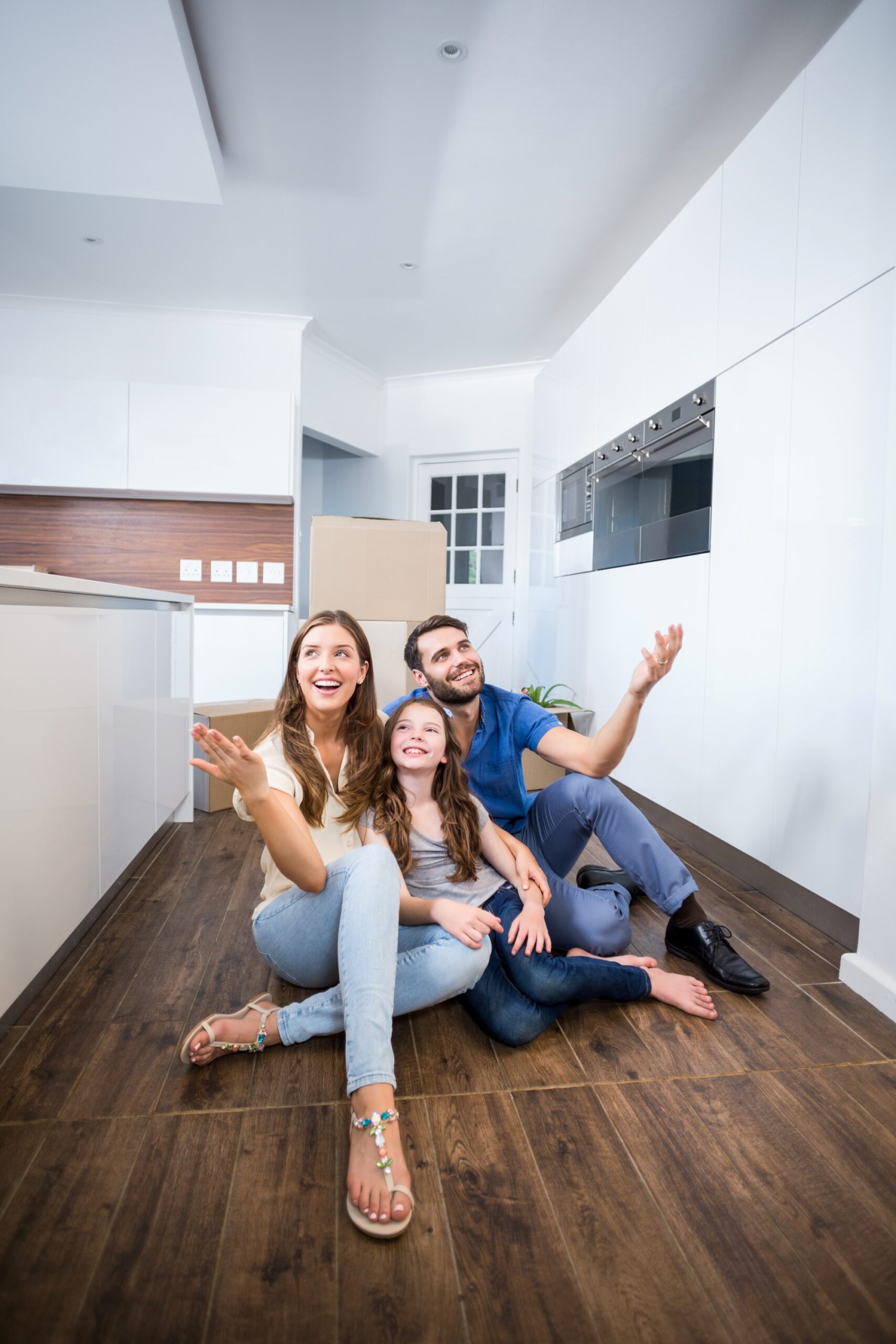 Familia feliz sentada en el piso de su nueva casa