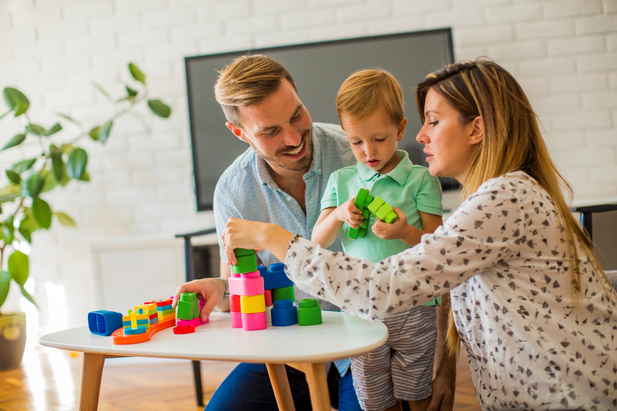 Niño jugando con la madre y el padre en casa
