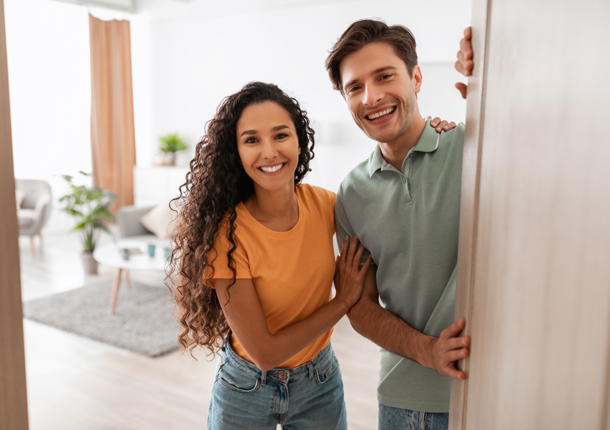 Feliz pareja joven que invitando a entrar a su nueva casa