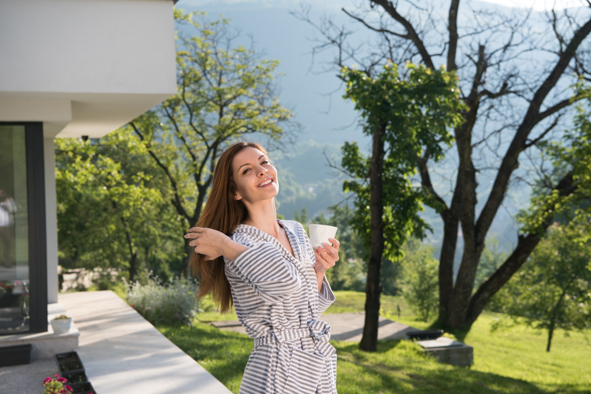 Joven mujer disfrutando de una hermosa mañana en su hogar sustentable