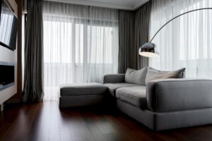 La Iluminación natural que entra através de los ventanales haces que la sala de estar se vea muy acogedor, con detalles de luz artificial focalizado en una parte del mueble para proyectar un ambiente de calidez.