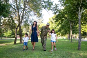 Familia feliz paseando por las áreas verdes del desarrollo inmobiliario donde tienen su nueva casa