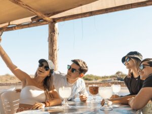 Jovenes tomandose una selfie y disfutando de mariscos fresco a la orilla del mar en Isla Cortes Nuevo Altata