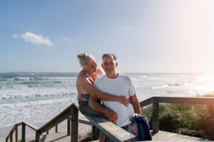 Matrimonio de la tercera edad desmuestran su felicidad al salir a pasear por la playa y haber comprado una casa de playa para vivir frente al mar