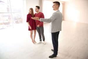 Agente inmobiliario mostrando a clientes una casa nueva