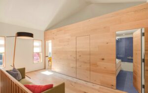 Diseño interior minimalista moderno con puertas ocultas con acabados en madera color natural