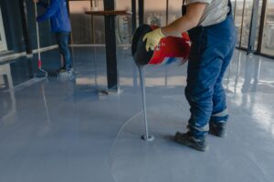 El trabajador aplica resina epoxi gris al nuevo piso
