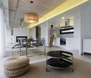 Espacios integrados funcionales y modernos de casa residencial joven se encuentra cocinando en la cocina