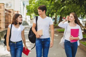 Estudiantes alegres caminando rumbo a la escuela en un entorno seguro tranquilo cercano a su hogar
