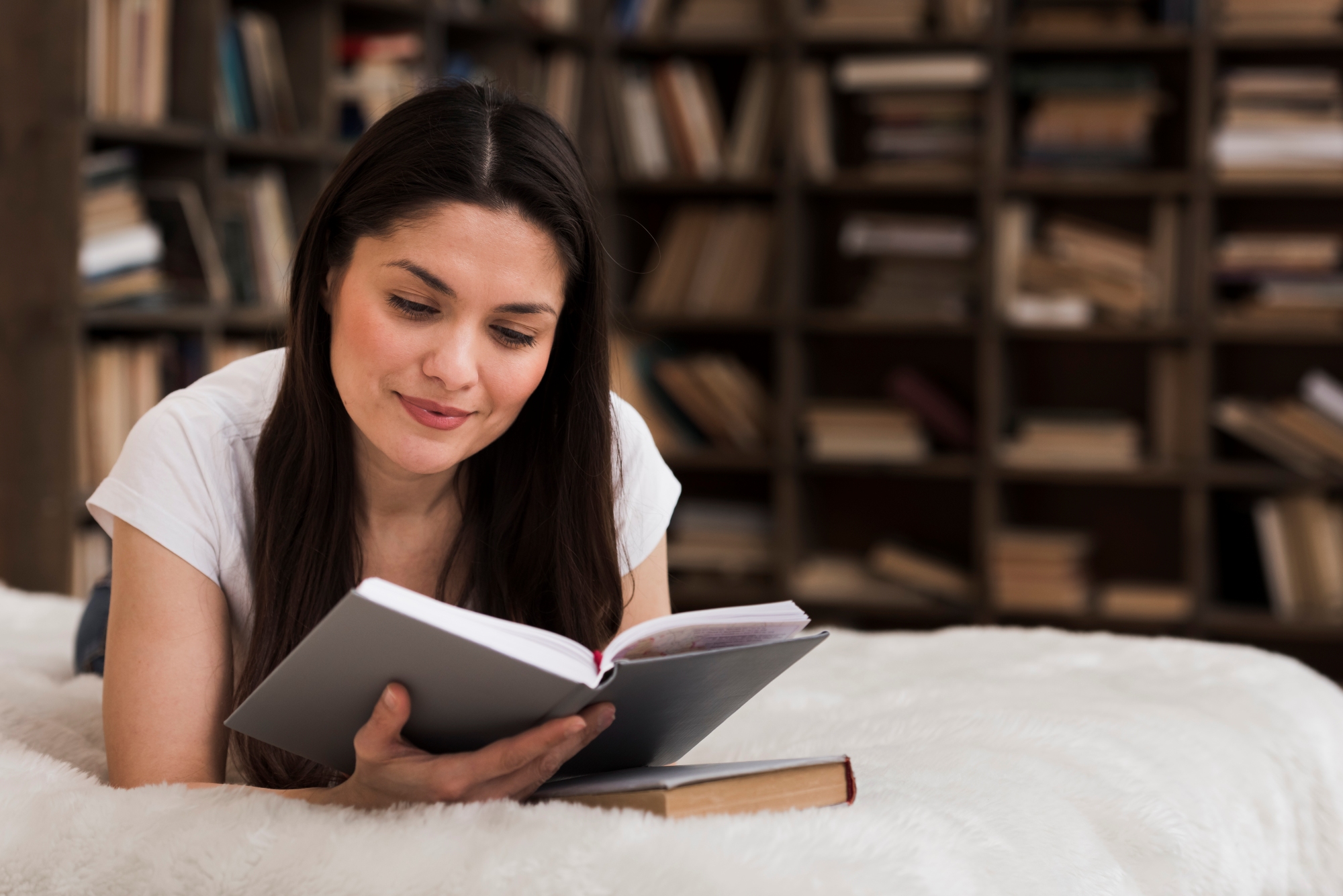 Joven mujer disfrutando de la lectura de un libro cutilvando su intelecto