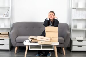 Mujer joven ocupada sentada en la sala de estar se ve su cara con frustración