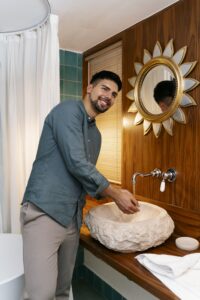 vista-lateral-sonriente-hombre-lavandose-las-manos en baño decorado bien